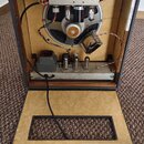 Fotografie znázorňuje otevřený kytarový kombozesilovač s odstraněným zadním panelem. Uvnitř je vidět elektronický zapojení s vakuovými elektrony, tra…