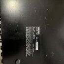 Fotografie zachycuje spodní část černého elektronického zařízení s viditelným štítkem. Na štítku je uveden nápis YAMAHA, MODEL TMX a SER NO 004127. D…