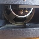 Detailní pohled na reproduktor v kabeňce. Na černé membráně jsou bílé a zlaté nápisy „CELESTION“, „LOUDSPEAKER“, „G12“ a „Vintage“. Kovový rám reprod…