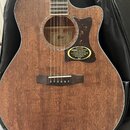 Akustická kytara s cutawayem, vyrobená z hnědého dřeva s viditnou strukturou slz. Na korpusu je tmavý pickguard s žlutými skvrnami a bílý nápis FEATU…