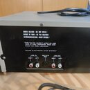 Zadní strana černého elektronického zařízení s několika konektory. Na povrchu jsou bílé nápisy: „SHOCK HAZARD - DO NOT OPEN ! RISQUE DE CHOC - NE PAS…