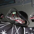 Fotografie zachycuje zadní část černé elektrokitary s otevřenými dutinami pro elektroniku. V hlavní dutině je vidět svazek červených, bílých a černýc…