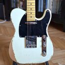 Elektrická kytara typu Telecaster v krémové barvě s černým pickguardem a světle barevným hmatníkem z javoru. Lak na těle vykazuje výrazné opotřebení…