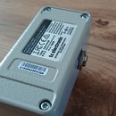 Fotografie zachycuje spodní stranu šedého efekt pedálu z kovu. Na spodní straně je nalepený štítek s nápisy „tc electronic“, „DESIGNED AND ENGINEERED…