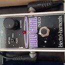 Kytarový efekt pedál v bílém rámu s černým povrchem. Na zařízení jsou nápisy „electro-harmonix“, „HOLY GRAIL NEO“ a „REVERB“. K ovládání slouží jeden…