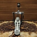 Stříbrný bubnový pedál s černými komponenty a bílým šlapadlem. Na šlapadle je umístěn kulatý černý štítek s bílou číslicí 6 a v dolní části logo znáz…