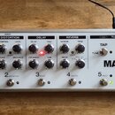 Stříbrný efektový procesor s nápisy T-REX a MAGNUS by TREX ENGINEERING Denmark. Zařízení obsahuje pět sekcí s ovládacími knoflíky a přepínači, označe…