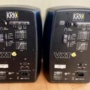 Dva černé studiové monitory značky KRK SYSTEMS. Na zadním panelu obou přístrojů je bílý a žlutý nápis VXT6. Jsou vidět různé ovládací prvky, grafy, k…