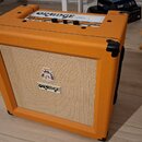 Kytarový kombozesilovač v oranžovém vinylu s béžovou textilní maskou. Na předním panelu je logo ORANGE a nad ním malý štít s nečitelným textem. Horní…
