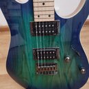 Elektrická kytara s modro-zeleným přechodovým lakem a viditnou strukturou dřeva. Nástroj má dva humbuckery, most typu Tune-o-matic a dva oválné ovlád…