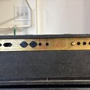 Zadní panel kytarového komba v černé texturované koženkové obalovce se zlatým kovovým panelem. Na panelu jsou nápisy MODEL: 4211, OUTPUT POWER: 100W,…