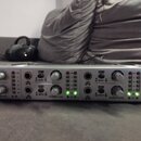 Stříbrný sluchátkový zesilovač s nápisy Mini AMP a 4-CH HEADPHONE AMP. Na předním panelu jsou ovládací knofíky, vstupy A INPUT B pro kanály CH 1 až C…