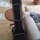 Černý poloměký pouzdro (gig bag) na hudební nástroj s bílým lemováním lemů a zipů. V dolní části je bílý nápis Hartwood. Pouzdro má dvě zipované přih…