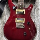 Elektrická kytara s tmavě červeným lakovaným povrchem a dvěma humbuckery v krémových rámečkách. Na hmatníku jsou vidět vložky ve tvaru ptáků. Kytara…