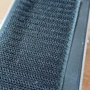 Fotografie zachycuje spodní stranu efekt pedálu v kovovém stříbrném provedení. Na spodku je přilepený černý texturovaný suchý materiál, který vykazuj…