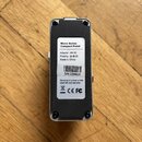 Zadní strana stříbrného efekt pedálu z kovu. Na bílém štítku je text „Micro Series Compact Pedal“, „Adapter: 9V“, „Polarity: (symbol polarity)“, „Mad…