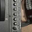 Detail ovládacího panelu černého komba s nápisem BOSS na rukojeti. Panel obsahuje sekci EQUALIZER s knoflíky BASS, MIDDLE a TREBLE, sekci EFFECTS s k…