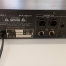 Zadní strana šedého mixážního pultu s nápisem KAWAI 16 INPUT STEREO MIXER MX-8SR. Na šasi jsou vidět varovné nápisy CAUTION a AVIS: RISQUE DE CHOC ÉL…