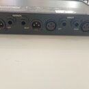 Záběr na zadní panel černého elektronického zařízení. Jsou zde vidět konektory s popisky OUTPUTS (LEFT, RIGHT) a INPUTS (LEFT, RIGHT). Na horní části…
