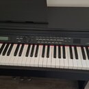 Černý digitální piano s bílými a černými klávesami. Na pravé straně ovládacího panelu je bílý nápis DP330. Panel obsahuje displej, několik ovládacích…