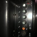 Detailní pohled na ovládací panel černého zvukového zařízení. Panel obsahuje pět otočných potenciometrů s popisky VOL, LOW, MID, HIGH a GAIN, u který…