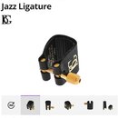 Černá kožená ligature s kovovými zlatými prvky. Na povrchu kůže je vyražené logo BG. V horní části vnitřku jsou nečitelné nápisy. Pod hlavním obrázke…