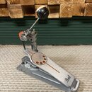 Kovový basový pedál s logem Pearl na šlapce. Nástroj má stříbrný kovový povrch s oranžovými detaily na mechanismu a v drážce šlapky. Povrch vykazuje…