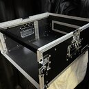 Černý transportní kufr z materiálu připomínajícího překližku s hliníkovými hranami a rohy. Kufr je vybaven dvěma kovovými zámky, madlem a vnitřním př…