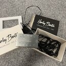 Na fotografii je stříbrný zdroj napájení s nápisy „Harley Benton“, „POWERPLANT ISO-1 PRO“ a „ISOLATED POWER SUPPLY“. Zařízení má několik výstupů ozna…
