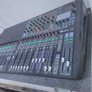 Černý mixovací pult s řadou posuvníků a ovládacích knoflíků. V horní části je nápis Soundcraft a označení Si. Zařízení vykazuje běžné známky používán…
