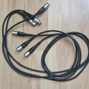 Na fotografii jsou dva černé audio kabely s konektory typu XLR. Kabely mají černou barvu a jsou svinuty do smyček na dřevěné podlaze. Na konektorech…