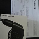 Fotografie zobrazuje krabičku od sluchátek s nápisy audio-technica a ATH-E40. Na krabici je zobrazen obrázek černých intraurálních sluchátek. Vedle k…