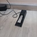 Černý sustain pedál z plastu s kovovým šlapadlem. Na horní části je vyražen nápis CASIO. Pedál je připojen k černému kabelu.