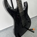Černá elektrická kytara s lesklým povrchem a tmavou hmatníkem. Nástroj má dva humbuckery, jeden ovládací knoflík a je umístěn na černém stojanu. Na t…