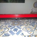 Červený digitální klavír s černým spodním panelem. Na levé straně je bílý nápis Roland a na pravé straně bílý nápis GO:KEYS. Nástroj je položen na vz…