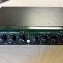 Zelený rackový procesor s nápisy JOEMEEK, OPTICAL COMPRESSOR a MEEQUALIZER. Zařízení obsahuje řadu černých otočných ovladačů s bílými popisky a někol…