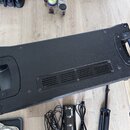 Černý obal na hudební nástroj z texturovaného materiálu s dvěma plastovými úchyty. V dolní části se nachází plastová ventilační mřížka s vodorovnými…