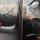 Detailní pohled na hmatník a hranu krku černého strunového nástroje. Na povrchu jsou vidět drobné prachové částice a stopy používání. Žádné značky an…