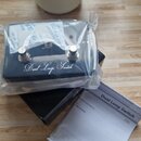 Černý kytarový pedál s nápisem Dual Loop Switch v plastovém obalu. Na horní části jsou dvě stoupacívky, přepínač A/B a nápisy SEND a LOOP A. Vedle pe…