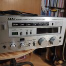 Stříbrný kazetový přehrávač s nápisem AKAI STEREO CASSETTE DECK model GX-F80. Na předním panelu jsou tlačítka PAUSE, REC a ovládací prvky s nápisy TA…