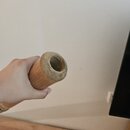 Fotografie zachycuje detail konce dřevěného, hnědého nástroje s kulatým průřezem. Viditelný je vnitřek dutiny, která vykazuje známky opotřebení a neč…