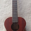 Hnědá ukulele z dřeva s tmavým hmatníkem. Na hlavě je zlatý nápis LANIKAL a uvnitř ozvučnice je viditelné logo LANIKAL. Nástroj vykazuje známky běžné…