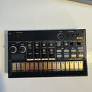 Černý kompaktní syntezátor s nápisy KORG a volca beats. Zařízení obsahuje řadu bílých ovládacích knofíků, tlačítek a digitální displej s červenými čí…