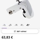 Fotografie znázorňuje snare trigger v chromovém, lesklém provedení. Zařízení má kovové tělo s utahovacím šroubem nahoře a konektorem na boku. Pod hla…