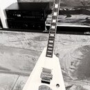 Bílá elektrická kytara s ostře hranatým tělem typu V. Na hlavě je viditelné logo značky ESP. Nástroj má dva humbuckery, Floyd Rose tremolo systém a j…