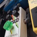 Bílý efekt pedál s nápisy „electro-harmonix“ a „NEW YORK CITY, USA“. Na horní části je grafika s nápisem „MAYON overdrive“ a označením „TREBLE“. Pedá…