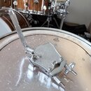 Stříbrný kovový pedál hi-hat s texturovaným povrchem základny. Na horní části je viditelný nápis "Ludwig". Předmět vykazuje známky používání v podobě…