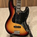 Elektrická basová kytara s korpusem v barevném přechodu od žluté přes oranžovou k červené a černé. Nástroj má černý pickguard, dva snímače a čtyři ov…