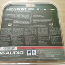 Fotografie znázorňuje zadní stranu obalu od produktu MIDISPORT Uno, což je 1-In/1-Out USB MIDI Interface. Na obalu jsou textové popisy v několika jaz…