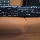 Zadní strana černého elektronického zařízení s nápisem FRACTAL AUDIO SYSTEMS. Jsou zde vidět různé vstupy a výstupy s popisky INPUT 1, INPUT 2 FX RET…
